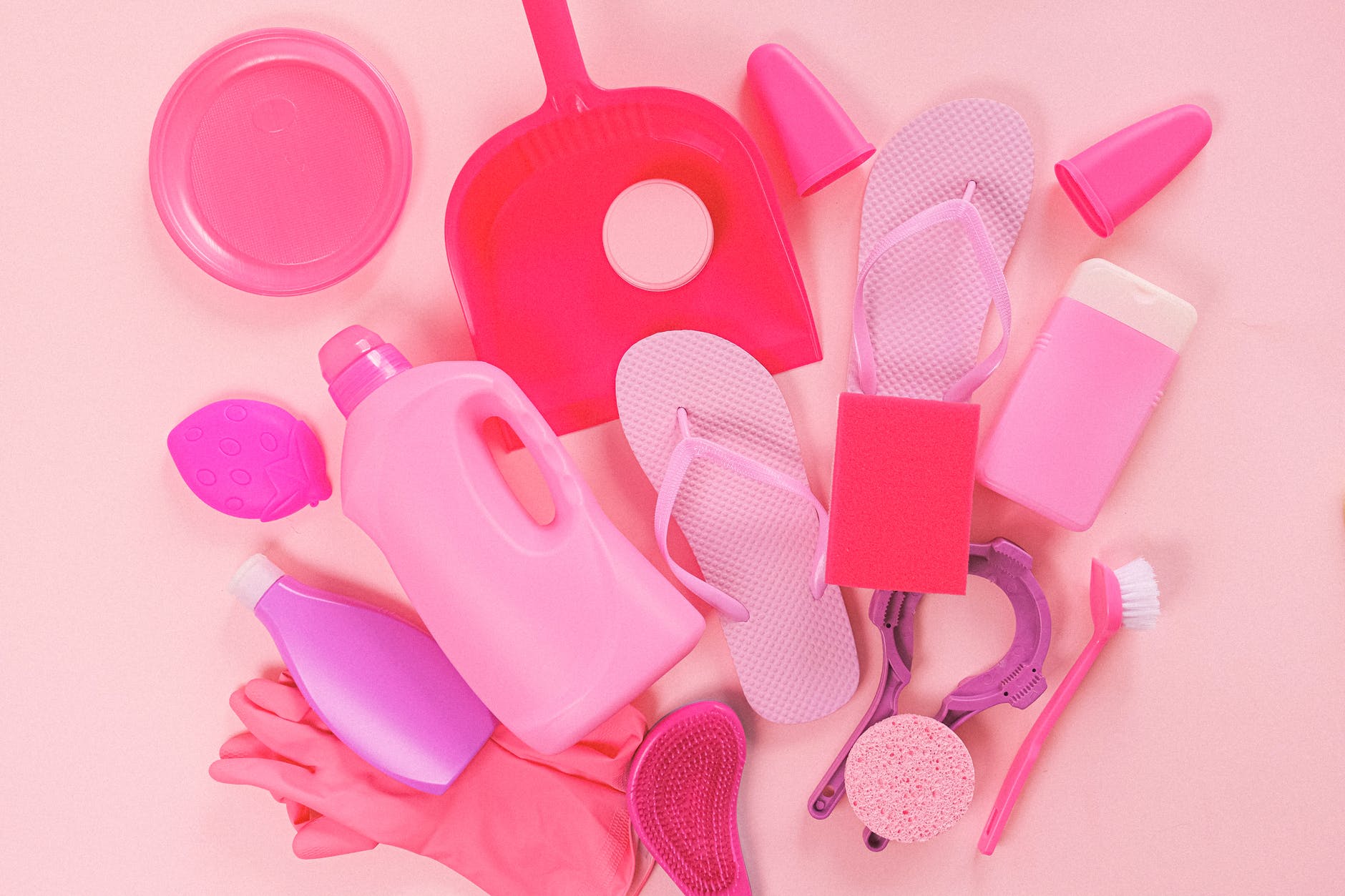 set of cleaning supplies on pink background