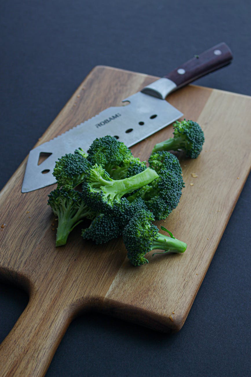 green broccoli on brown wooden chopping board