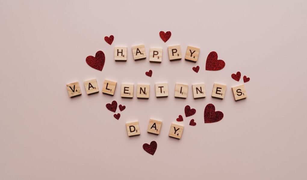 happy valentine s day text on pink surface